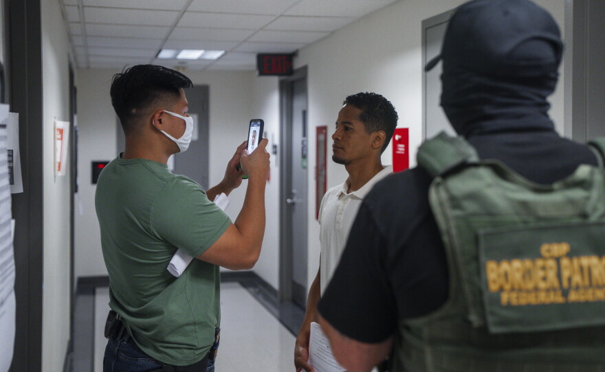 A federal immigration agent uses facial recognition software to confirm an asylum seeker's identity prior to an immigration hearing on July 30, 2025, in New York. In addition, DHS is expanding its use of iris scanners to help quickly identify undocumented immigrants.