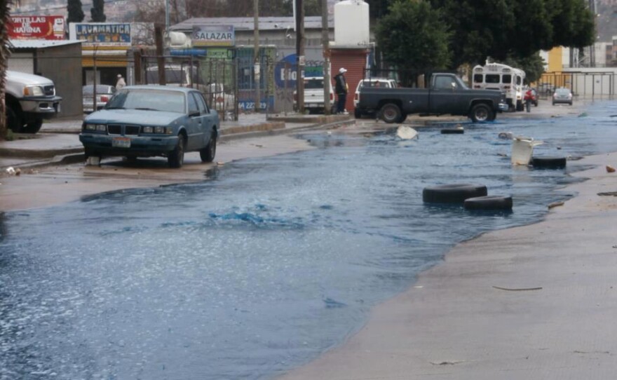 In an undated photo, neon blue water runs through a street near Arroyo Alamar after a rainy day.