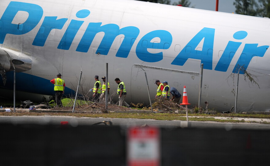 Workers inspect an Amazon cargo plane two days after it overshot a runway at Miami International Airport, Tuesday, Sept. 8, 2026, in Miami.