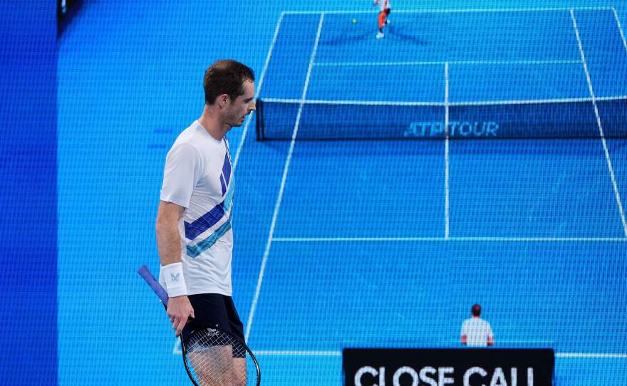 Andy Murray of Britain walks by as the result of a line call challenge Hawk-Eye review against Nikoloz Basilashvili of Georgia during their men's singles match at the Sydney Classic tennis tournament in Sydney on Jan. 12, 2022.