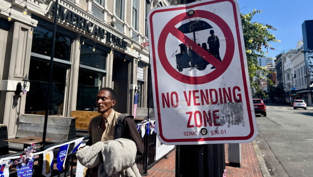 A man walks past a "No Vending Zone" sign in downtown San Diego, July 7, 2026.