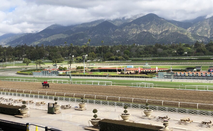 A few horses and riders are seen on the track at Santa Anita Park, in Arcadia, Calif., in March. Fifty-six horses have died there since July 2018.