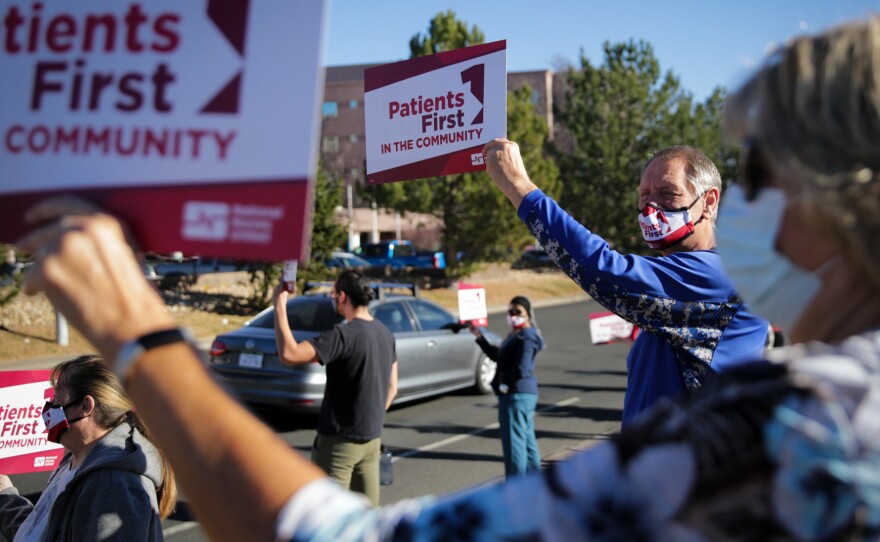 Longmont High School teacher and coach Jeff Kloster holds a sign in support of Longmont United Hospital nurses on December 2, 2021, outside the hospital. His wife Kris, a nurse there, was one of the speakers at the protest.