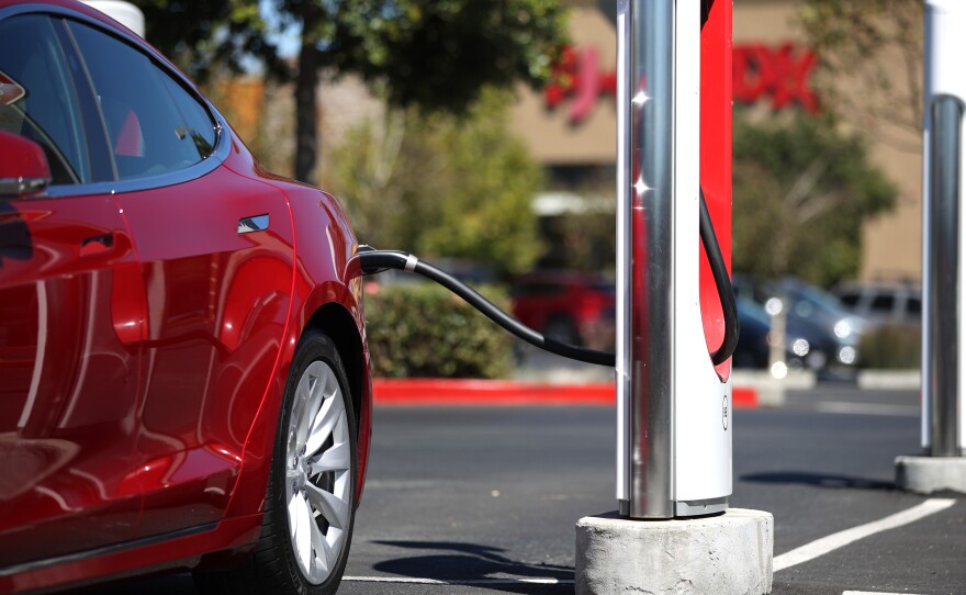 A Tesla car powers up at a charging station in Petaluma, Calif., on Sept. 23. Automakers are trying to convince would-be electric car buyers to adopt new habits to power their vehicles.