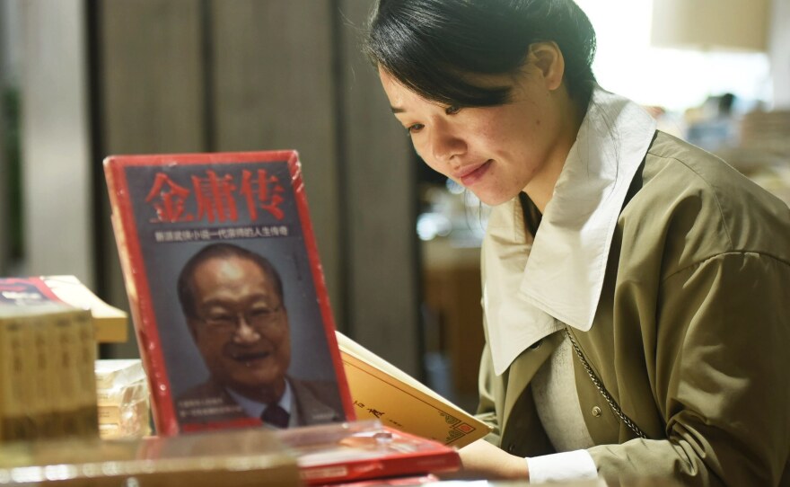 Novelist Jin Yong — the pen name for writer and journalist Louis Cha — has died, triggering tributes and mourning from his fans. Here, a customer reads a book at a memorial section at a bookstore in Hangzhou, Zhejiang Province.