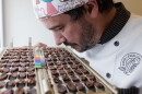 Julien Simonis, Programme Manager for Cacao of Excellence, smells and meticulously inspects halved cocoa beans during a physical quality evaluation at the laboratory in Perugia. This sensory and visual assessment allows for the immediate verification of fermentation levels and the identification of aromatic potential or internal defects in the samples