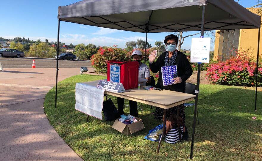 Poll workers stands outside the Malcom X Branch Library, a ballot drop off location in San Diego County. Oct. 31, 2020. 