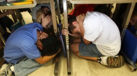 Students of Stevenson Elementary School in Los Angeles drop, cover and hold on during the simulation of an expected catastrophic 7.8 magnitude earthquake on the San Andreas Fault during the Great Southern California ShakeOut earthquake drill.