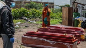 Family members of people who died of Ebola stand next to coffins at a health center in Rwampara, Congo, Wednesday, May 20, 2026.
