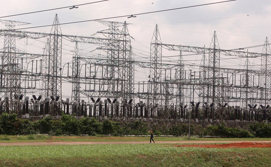 An employee walks past a power plant's electricity pylons in Lagos, Nigeria. Power shortages are particularly a problem for Nigeria's booming tech industry, which accounts for nearly 14% of the country's GDP.