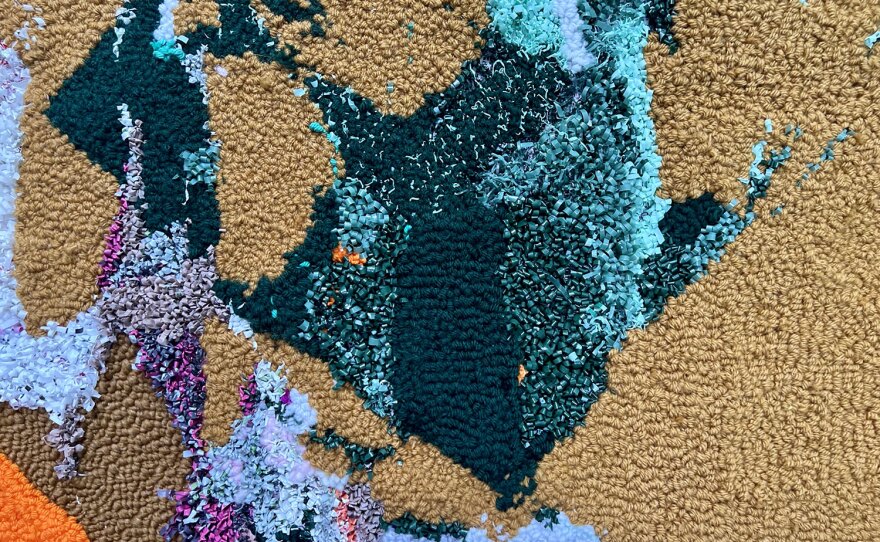 Detail of work by artist Mark Chamness shows the blend of yarn and scavenged plastic trash tufted into the textile.