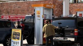 A woman cleans her windshield as another woman pumps gas at a Circle K gas station in Chula Vista, March 5, 2026.
