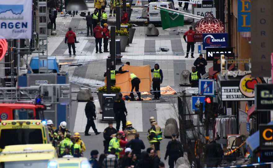 Emergency crews work at the scene where a truck crashed into the Ahlens department store in central Stockholm on Friday.