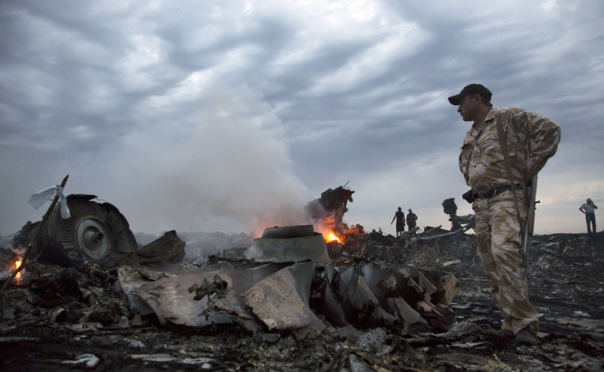 People walk near the debris at the crash site of a plane near Grabovo, Ukraine, on Thursday.