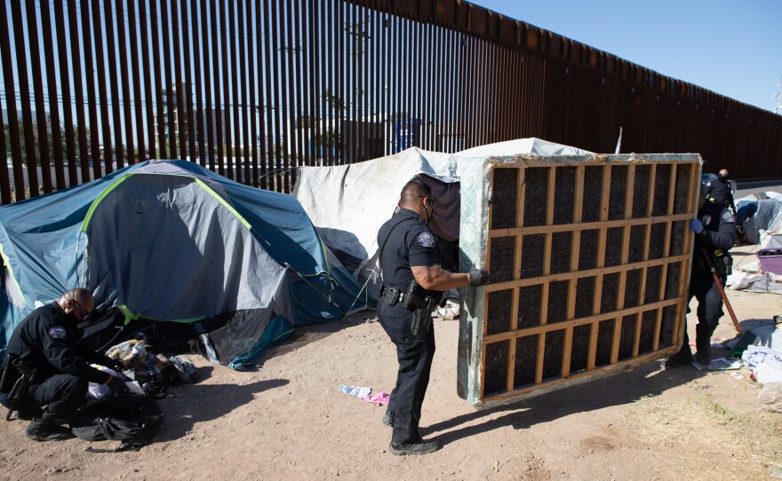 Calexico police officers remove a mattress from a tent at the farmworkers encampment, April 7, 2020.