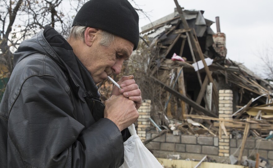 A man smokes next to a bombed out house near Donetsk airport in the city of Donetsk, eastern Ukraine on Sunday.