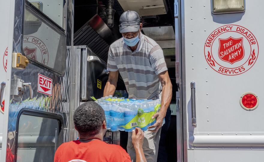 Booker Ellis, an employee at the Mississippi Industries for the Blind and Walter Houston, a Salvation Army employee, unload water donated by the Salvation Army in Jackson.