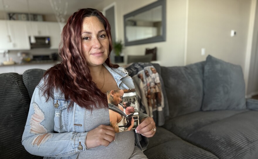 Britny Calloway holds a photograph of her husband, James Calloway, and their son in her home on Thursday, Jan. 15, 2026.
