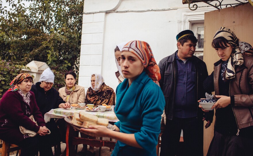 Tatars gather for the funeral of Edem Asanov, 25, who disappeared and was later found hanged in an abandoned building.