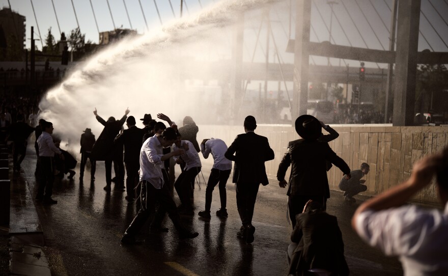 Police use water cannon to disperse ultra-Orthodox Jewish men blocking a street during a protest against the country's military draft in Jerusalem, April 29.