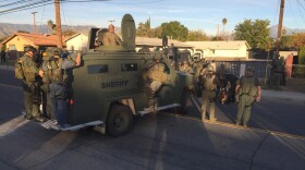Law enforcement officials with armored vehicles search an area near where police stopped an SUV believed to be connected to a mass shooting in San Bernardino, Dec. 2, 2015. 