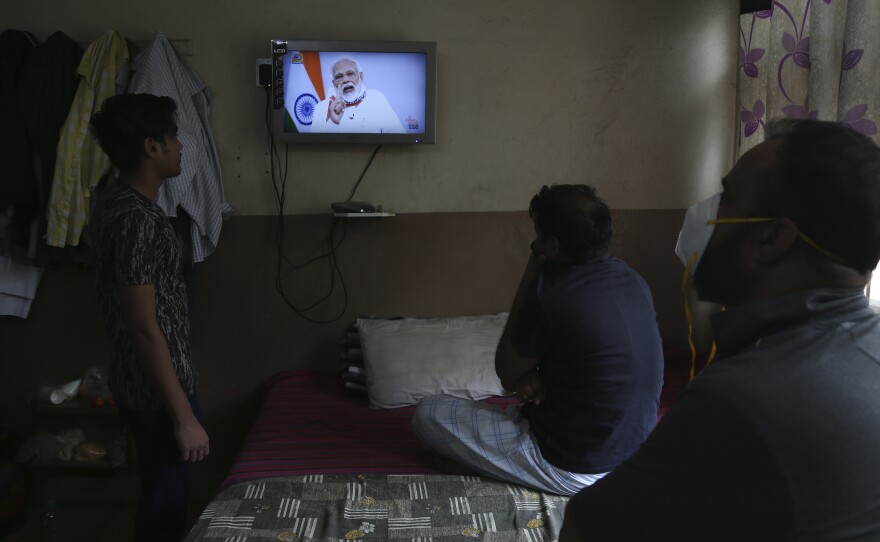 People in Hyderabad, India, watch Prime Minister Narendra Modi address the nation Tuesday. Modi has extended the world's largest coronavirus lockdown in hopes of reducing the epidemic's peak.