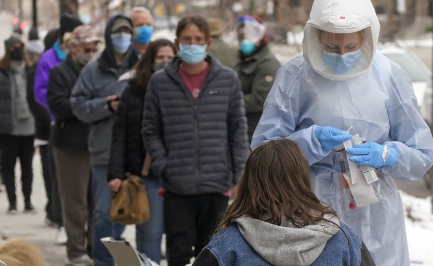 A member of the Salt Lake County Health Department COVID-19 testing staff performs a test outside the Salt Lake County Health Department on Tuesday in Salt Lake City.