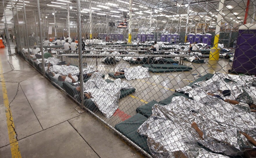 Detainees sleep and watch television in a holding cell where hundreds of mostly Central American immigrant children are being processed at a U.S. Customs facility in Nogales, Texas.