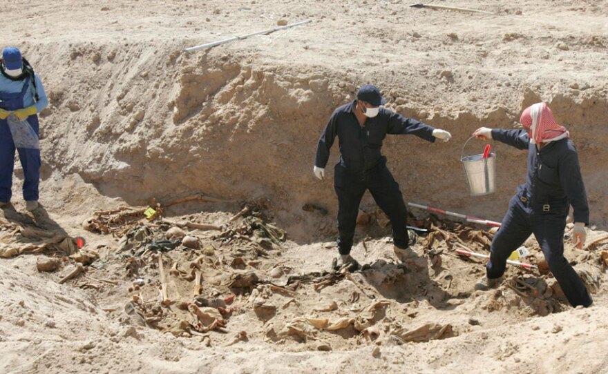 Workers excavate remains from a mass grave in the desert of western Anbar province in Iraq on April 14. The mass grave holds the remains of more than 800 people, believed to have been killed during the rule of ousted leader Saddam Hussein.