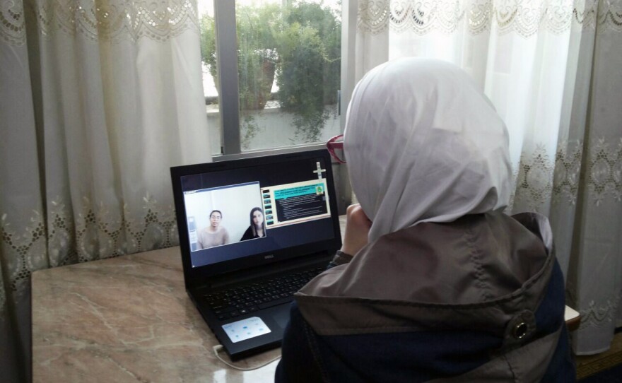 A student in Syria participates in an online English language class. She's one of the few students with a laptop; others use their mobile phone.