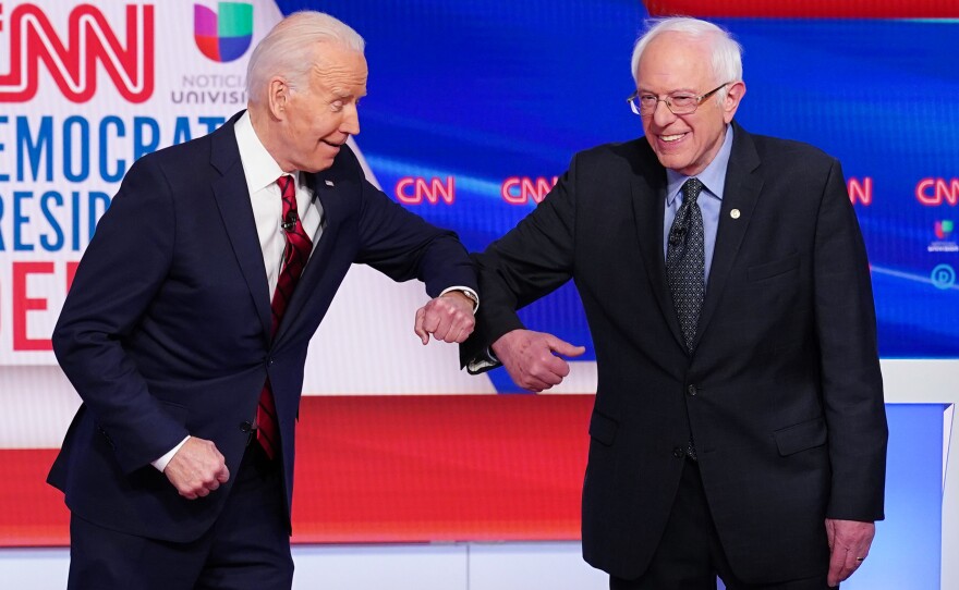 Joe Biden and Bernie Sanders touch elbows, as they greet each other for a Democratic presidential debate last month.