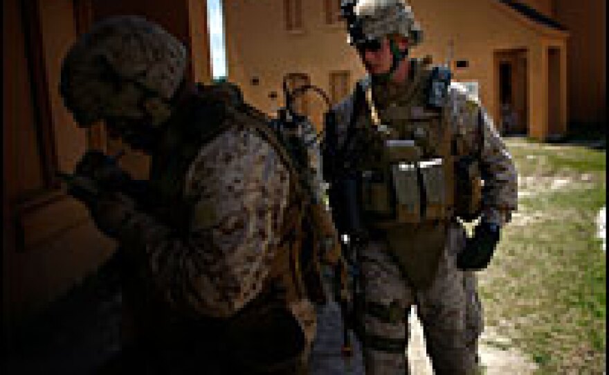 2nd Lt. Samuel Oliver, a platoon leader, checks on a Marine during a training patrol in a replica village, originally designed to look like the Balkans. This will be Oliver's first deployment overseas.