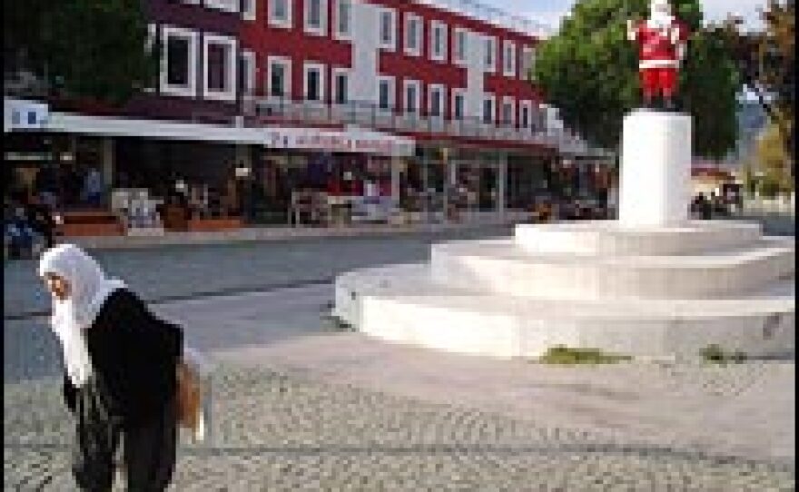 A Turkish woman passes in front of a controversial statue of Santa Claus, called Noel Baba in Turkish, in the town square of Demre. Last year, Russian diplomats criticized local Turkish officials, who replaced a bronze statue of a haloed Saint Nicholas, holding a Bible, with this more secular symbol of Christmas.