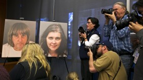 Members of the media photograph police photos of fifty-seven-year-old David Allen Turpin, left, and 49-year-old Louise Anna Turpin, center, during a news conference with Riverside County District Attorney Mike Hestrin in Riverside, Calif., Thursday, Jan. 18, 2018.