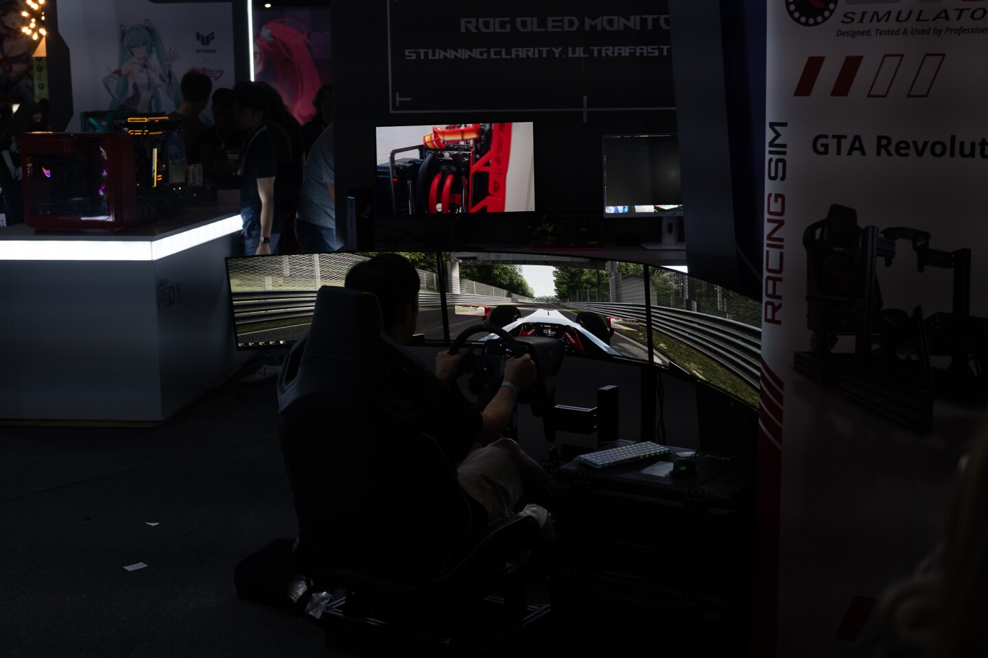 A convention attendee plays a driving game at the Revolution of Gaming booth at TwitchCon San Diego on Oct. 17, 2025.