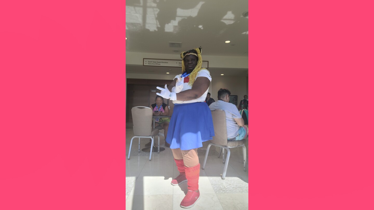 A woman, Chioma Iheme, wearing a Sailor Moon costume posing at Comic-Con.