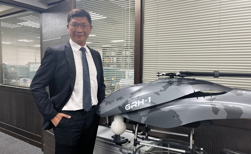 Lo Cheng-Fang, the founder of Geosat, poses for a portrait next to a tactical helicopter made by the drone company.