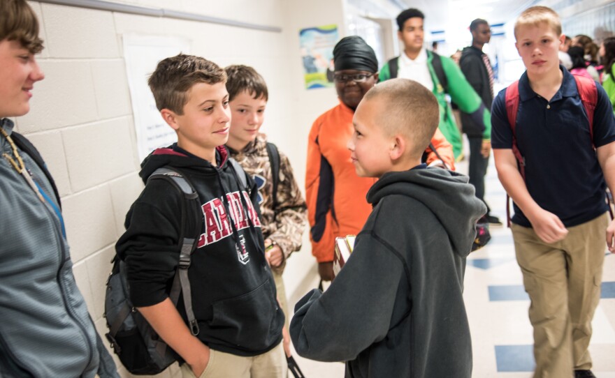 North middle school student and protege of Robert Gordon, Casey Robinson (second from left) chats with classmates in the hallway. Gordon has been preparing Robinson to take over his role after graduation.