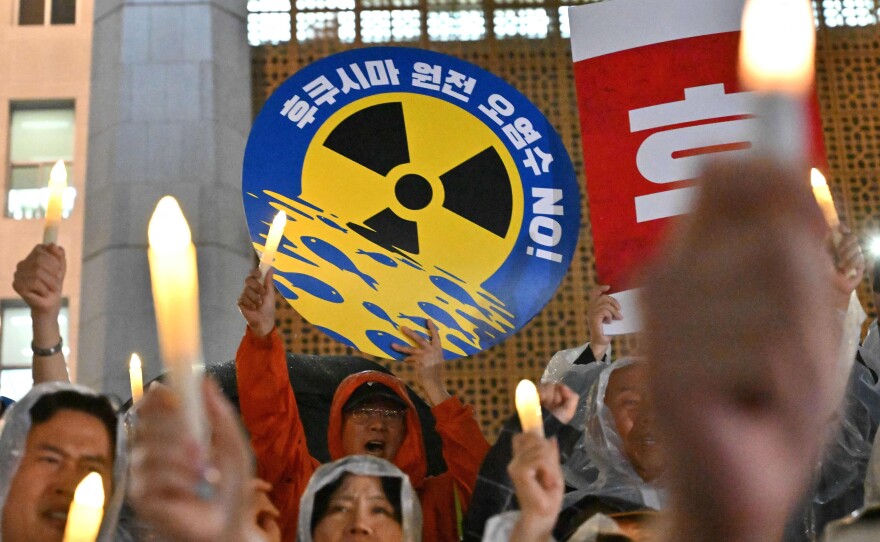 South Korea's main opposition Democratic Party members hold electric candles and a sign reading "No Fukushima nuclear contaminated water!" during a rally against Japan's plan on Wednesday. Other Pacific nations are also worried by the release.