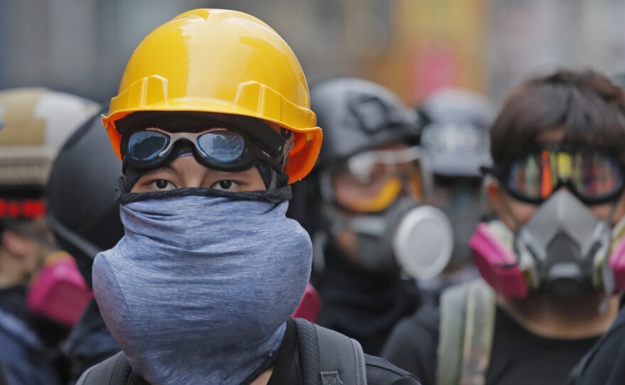 Protesters with protective gear face riot police in Hong Kong on Sunday.