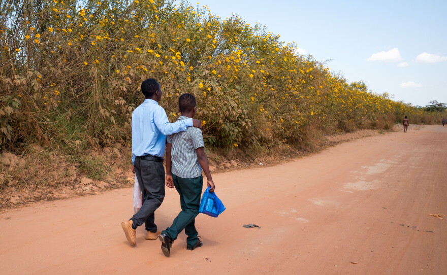 Gift and Alumbwe walk to school. Gift hopes to become an engineer; Alumbwe wants to be a soldier.