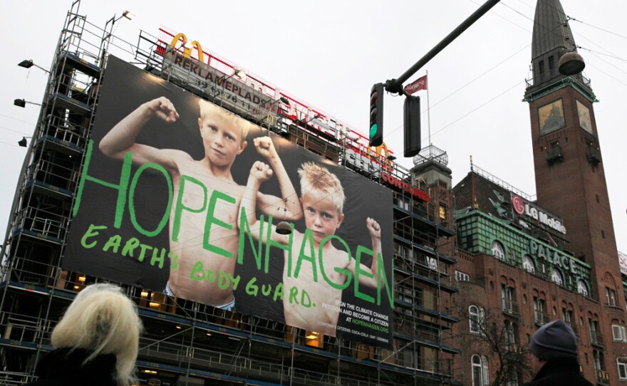 Pedestrians wait at a crossing opposite a poster reading "Hopenhagen Earth Body Guard" in Copenhagen, Denmark. Representatives from more than 190 nations are gathered in the city to negotiate a new international deal about global warming.