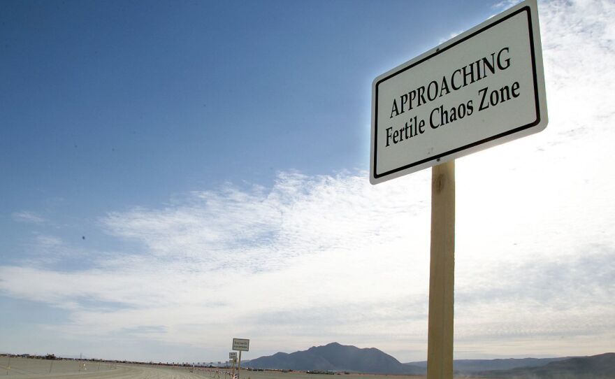 A sign is posted at the entrance checkpoint for the Burning Man festival in Nevada's Black Rock Desert in 2000. The festival's co-founder, Larry Harvey, died on Saturday at 70 after suffering a massive stroke.