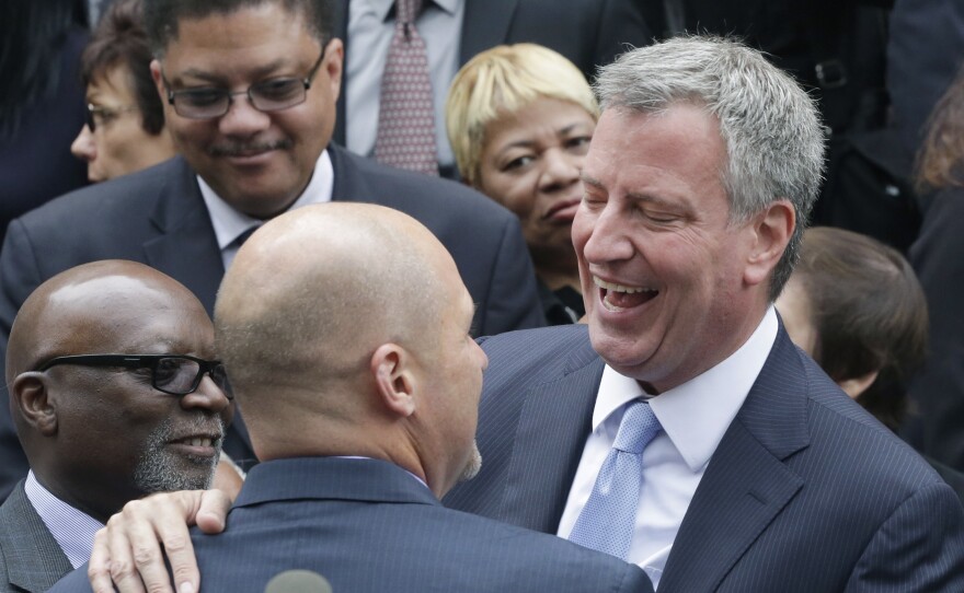 Democrat Bill de Blasio embraces a supporter on the steps of City Hall on Monday.