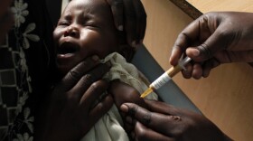 <p>A mother held her baby as she received an experimental malaria vaccine at the Walter Reed Project Research Center in Kombewa in Western Kenya in Oct. 2009. </p>
