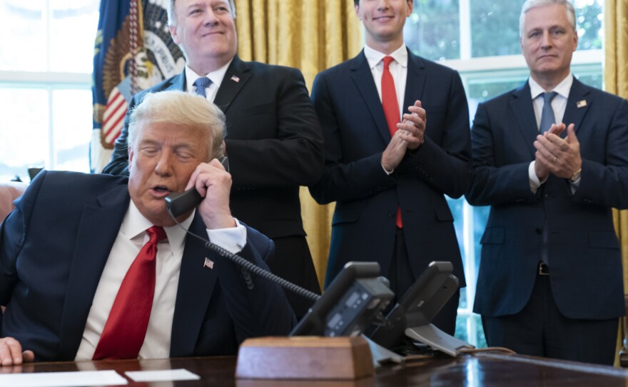 In this 2020 file photo, former President Donald Trump speaks with the leaders of Sudan and Israel by phone, as his foreign policy advisers applaud.