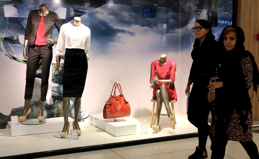 Iranian women walk past a window display in Tabriz in northwestern Iran on Oct. 15. Iran is facing a host of economic problems as world oil prices fall and international sanctions remain in place.