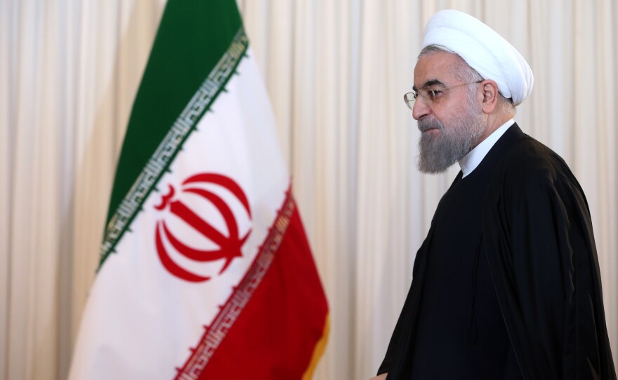 Iran's President Hassan Rouhani leaves after a televised speech in Tehran on Dec. 16. Iran has been dismantling parts of its nuclear program as required under an international deal, and some sanctions could be lifted as soon as January.