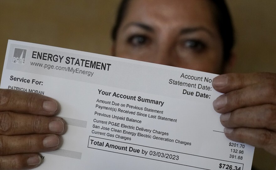 Patricia Moran holds up a utility bill while posing for photos at her child care facility in San Jose, Calif., Wednesday, Feb. 15, 2023.