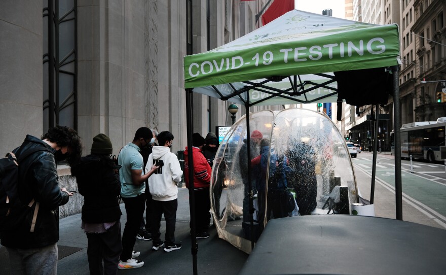 People line up to get tested for COVID at a site in New York City on Monday. The new omicron variant, first detected in South Africa, is quickly spreading around the world.